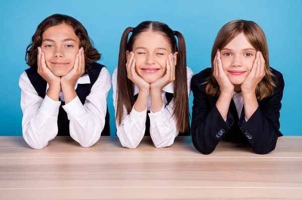Фотопортрет одноклассники улыбаются в форме сидя за столом веселый изолированный пастельно-синий цвет фона — стоковое фото
