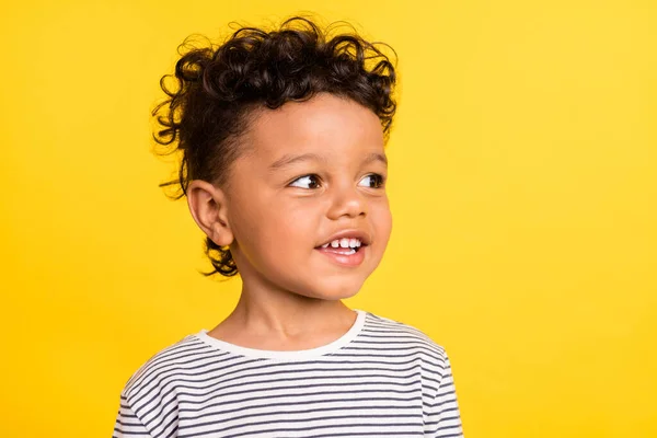 Фотопортрет веселий маленький хлопчик виглядає порожнім простором, посміхаючись у смугастій сорочці ізольований яскраво-жовтий кольоровий фон — стокове фото