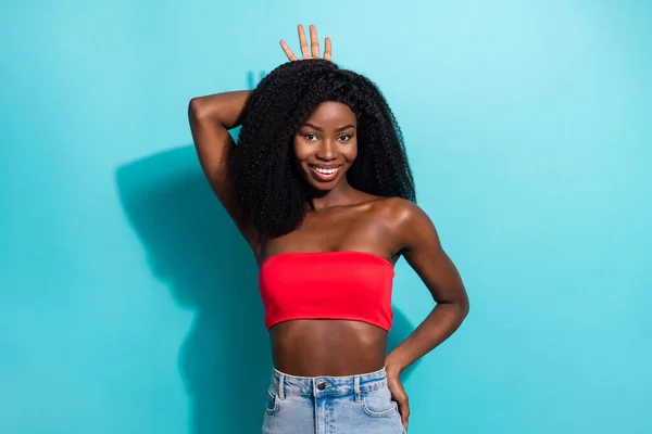 Foto von cool liebenswert dunkelhäutige Frau gekleidet rot Crop Top lächelnd zeigt Finger Krone isoliert blaue Farbe Hintergrund — Stockfoto