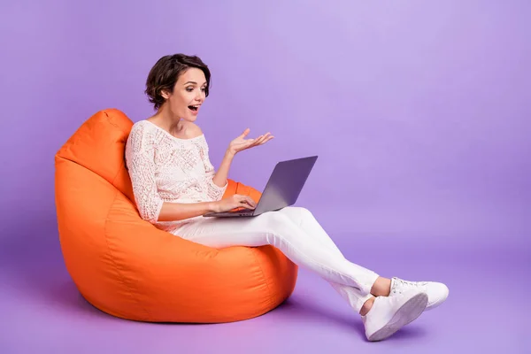 Full storlek profil porträtt av positiv person som sitter mjuk stol tala videochatt isolerad på lila färg bakgrund — Stockfoto