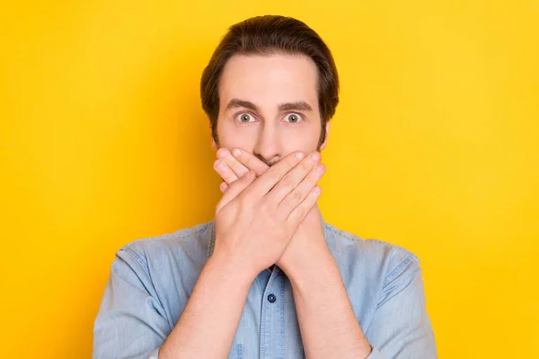 Retrato fotográfico de un hombre joven cubierto de boca con las manos manteniendo el secreto aislado sobre un fondo de color amarillo vivo — Foto de Stock