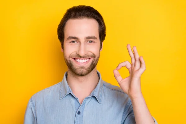 Foto retrato de un joven sonriente mostrando un gesto bien aislado sobre un vibrante fondo de color amarillo — Foto de Stock