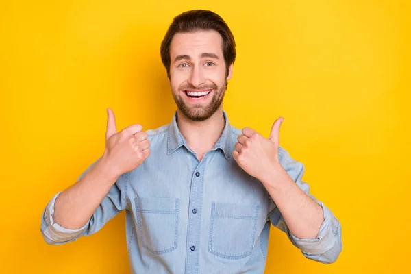 Retrato fotográfico de un joven riendo mostrando el pulgar hacia arriba como un signo aislado sobre un vibrante fondo de color amarillo — Foto de Stock