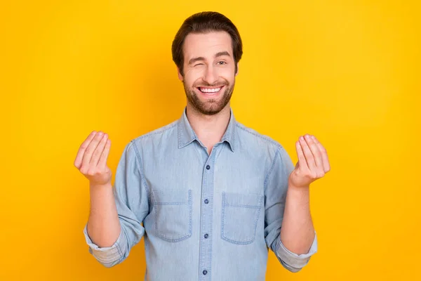 Foto retrato de un joven sonriendo pidiendo dinero guiñando un ojo positivo aislado sobre fondo de color amarillo brillante —  Fotos de Stock