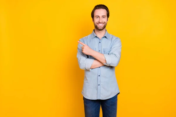 Фото молодого веселого чоловіка щаслива позитивна посмішка вказує палець на порожній простір вибирайте пропонуйте ізольовані на жовтому кольоровому фоні — стокове фото