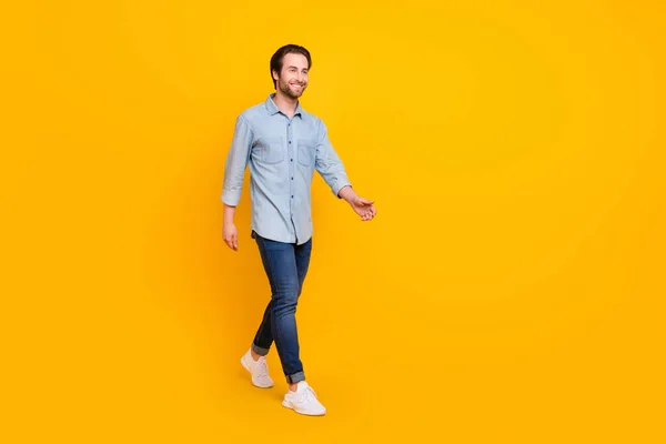 Foto lateral de perfil de longitud completa de hombre alegre joven sonrisa positiva feliz ir caminar buscar espacio vacío aislado sobre fondo de color amarillo — Foto de Stock