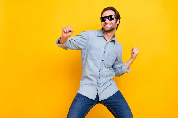 Foto von jungen aufgeregten Mann glücklich positives Lächeln clubber Tanzparty Sonnenbrille isoliert über gelbem Hintergrund — Stockfoto