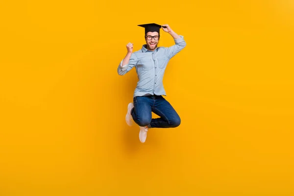 Piena lunghezza foto di giovane felice sorriso positivo saltare su gioire master laurea cappello isolato su sfondo di colore giallo — Foto Stock