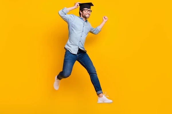 Volledige lengte profiel zijkant foto van de jongeman gelukkig positieve glimlach sprong gaan lopen master degree geïsoleerd over gele kleur achtergrond — Stockfoto