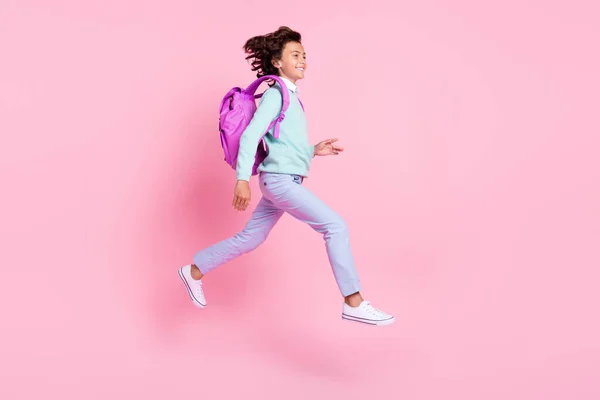 アクティブなスポーティな少年ジャンプのプロフィール写真急いで知識日の着用バックパックのテールシャツ孤立ピンク色の背景 — ストック写真