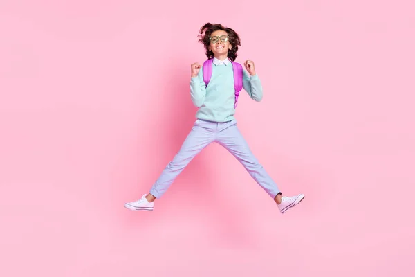 Foto von unbeschwerten Champion Schüler springen heben Fäuste tragen Brille Rucksack Kricketshirt isoliert rosa Farbe Hintergrund — Stockfoto