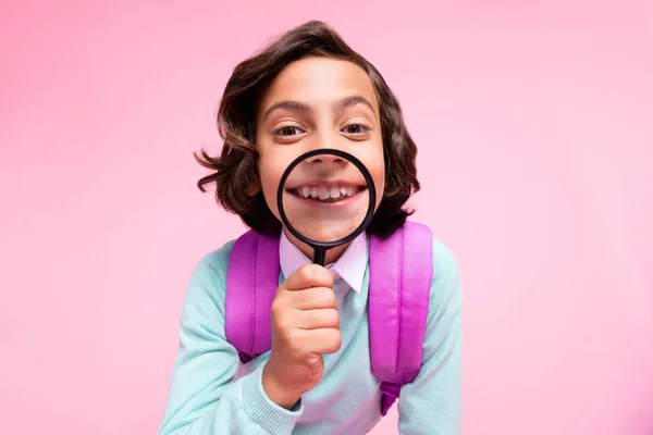 Foto von ehrlichen gesunden Jungen halten Lupe vergrößern strahlendes Lächeln tragen Tasche Krickenhemd isoliert rosa Farbe Hintergrund — Stockfoto