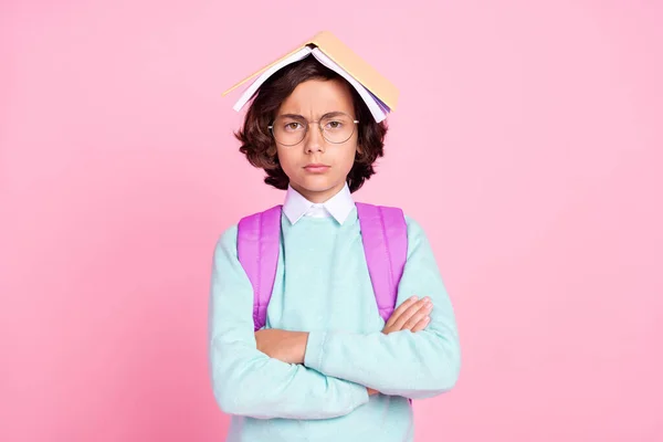 Foto de menino sério segurar livro capa cabeça cruzado mãos desgaste saco teal camisa isolado cor rosa fundo — Fotografia de Stock