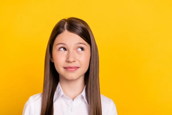 Фото любопытной вдумчивой школьницы смотреть пустое пространство думаю носить белую рубашку изолированный желтый цвет фона — стоковое фото