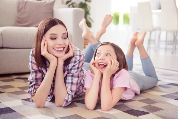 Portret van twee aantrekkelijke vrolijke meisjes liggen op de vloer plezier hebben goed humeur gek thuis flat binnen — Stockfoto