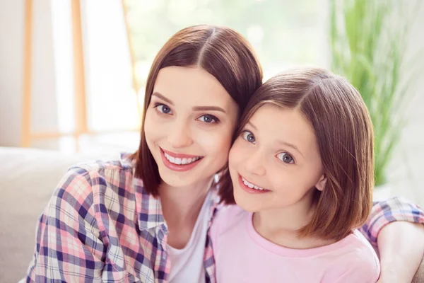 Photo of cheerful happy younger sister siblings sit sofa smile good mood trust indoors inside house home — Stock Photo, Image