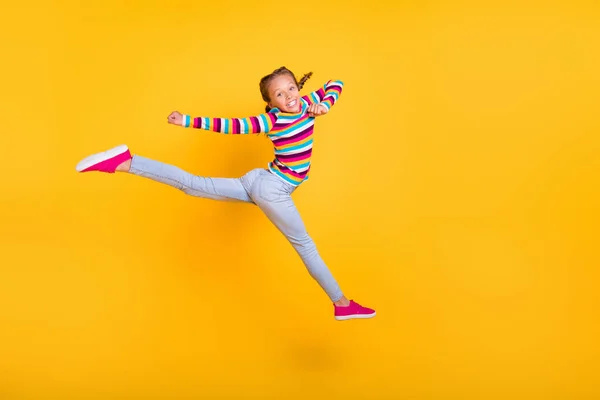 점프하는 멋진 여자의 프로필 사진은 이동을 즐기고 이동에 줄무늬 셔츠 청바지를 입고 이동 합니다. — 스톡 사진