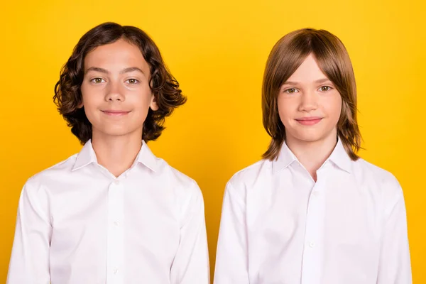 Foto de dos compañeros de clase positivos alegres colegiales mirar cámara usar camisa blanca aislado color amarillo fondo — Foto de Stock