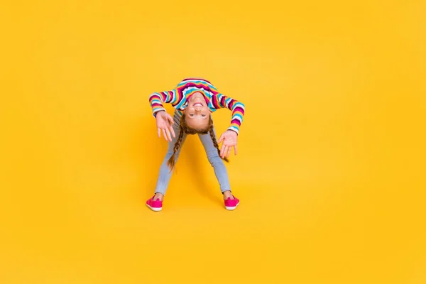 Foto de chica linda divertida estiramiento estancia puente desgaste camisa rayada jeans calzado aislado color amarillo fondo —  Fotos de Stock