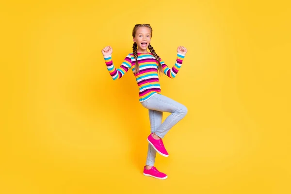 Foto de alegre señora asombrada celebrar la victoria desgaste camisa a rayas jeans zapatos aislados de color amarillo de fondo —  Fotos de Stock