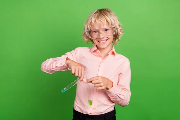 Zdjęcie szczęśliwy pozytywny mały chłopiec trzymać za ręce chemikalia nauka klasa izolowane na zielonym tle kolor — Zdjęcie stockowe