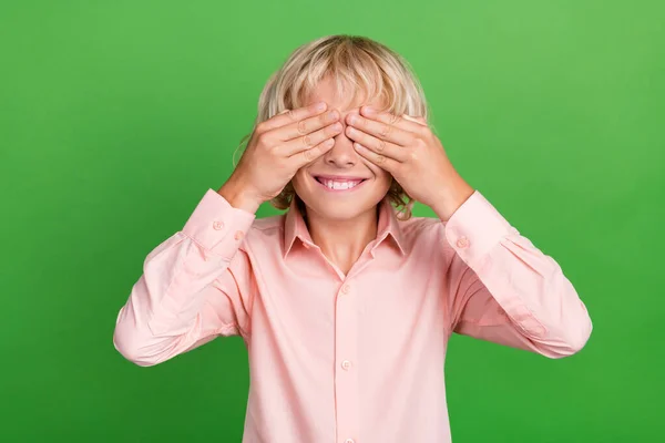 Foto de niño alegre alegre alegre joven cogido de la mano cubrir la cara ojos aislados en el fondo de color verde — Foto de Stock