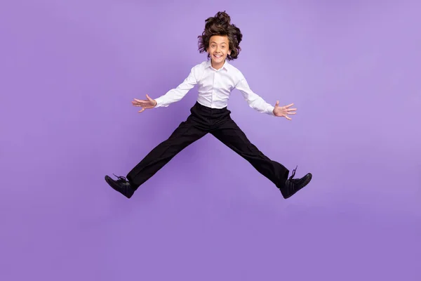 Foto corpo pieno di divertente piccolo ragazzo brunetta saltare indossare pantaloni camicia scarpe da ginnastica isolato su sfondo di colore viola — Foto Stock