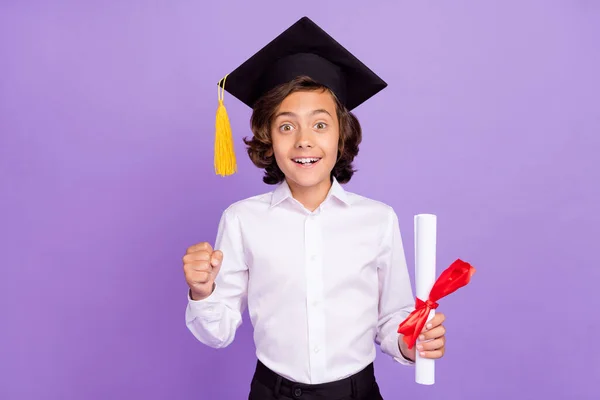 Fénykép vicces kis barna fiú hold papír kopás formalwear sapka elszigetelt lila színű háttér — Stock Fotó