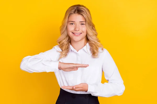 Foto van schoolmeisje handen houden maatregel lege ruimte dragen wit shirt geïsoleerde gele kleur achtergrond — Stockfoto