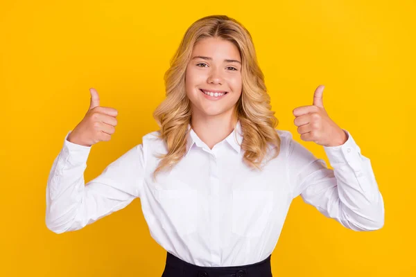 Foto van vrolijke schoolmeisje heffen twee duimen omhoog stralen glimmende glimlach dragen witte shirt geïsoleerde gele kleur achtergrond — Stockfoto