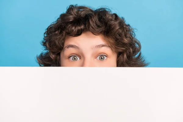 Foto van schattige onder de indruk schooljongen dragen witte shirt billboard cover mond geïsoleerde blauwe kleur achtergrond — Stockfoto