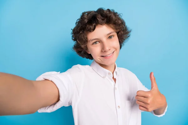 Komik bir okul çocuğunun fotoğrafı beyaz gömlek giyip gülümseyen bir video kaydıyla izole edilmiş mavi arkaplanı gösteriyor. — Stok fotoğraf