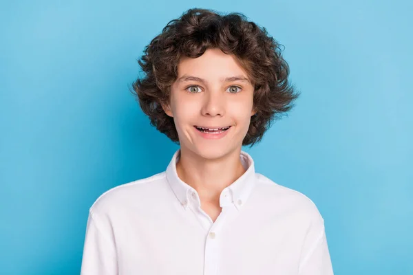Foto de impressionado engraçado escola menino desgaste branco camisa grande olhos sorrindo isolado azul cor fundo — Fotografia de Stock