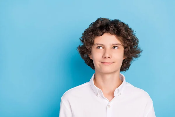 Foto von attraktiven verträumten Schuljungen tragen weißes Hemd suchen leeren Raum lächelnd isoliert blaue Farbe Hintergrund — Stockfoto