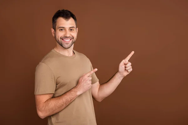 Fotoporträt brünetter Mann trägt pastellfarbenes T-Shirt, das Finger leeren Raum zeigt isoliert braunen Farbhintergrund — Stockfoto
