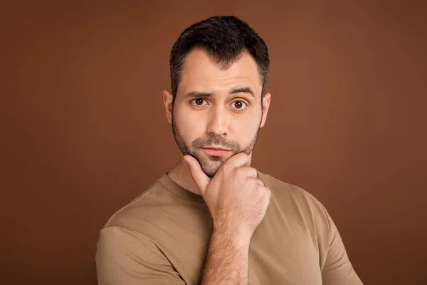 Foto retrato morena hombre usando pastel camiseta reflexivo tocando barbilla aislado color marrón fondo —  Fotos de Stock
