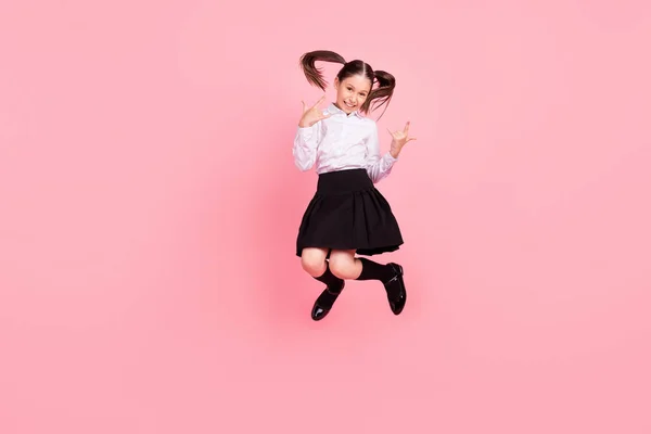 Corpo inteiro foto de feliz positivo morena caudas menina salto até desgaste formalwear uniforme mostrar rock canta salto isolado no fundo cor-de-rosa — Fotografia de Stock