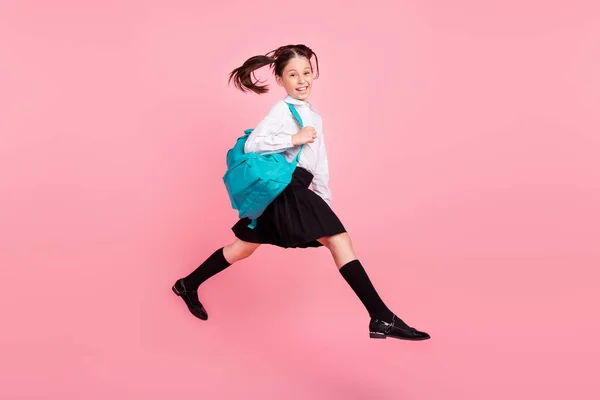 Foto de longitud completa de la chica positiva linda feliz saltar a pie llevar mochila lección aislado en el fondo de color rosa —  Fotos de Stock