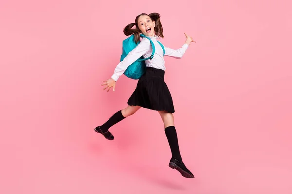 Foto de tamaño completo de chica positiva feliz loca saltar usar mochila sonrisa alumno aislado sobre fondo de color rosa —  Fotos de Stock