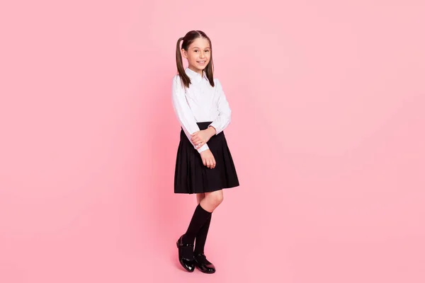 フルボディ写真の若い幸せな正の小さな女の子身に着けている制服笑顔学生孤立した上のパステルピンク色背景 — ストック写真