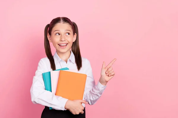 Foto de jovens feliz positivo pequeno ponto menina dedo vazio espaço sorriso segurar notas isoladas no fundo cor-de-rosa — Fotografia de Stock
