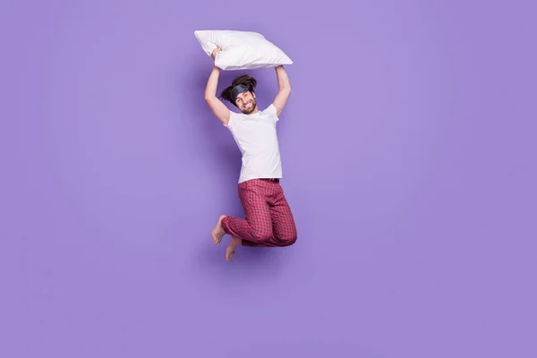 Полный портрет веселого беззаботного парня держать подушку над головой зубастый улыбка изолирована на фиолетовом фоне цвета — стоковое фото