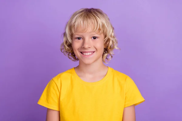 Foto de jovem alegre menino positivo sorriso bom humor usar camiseta amarela isolada no fundo cor violeta — Fotografia de Stock