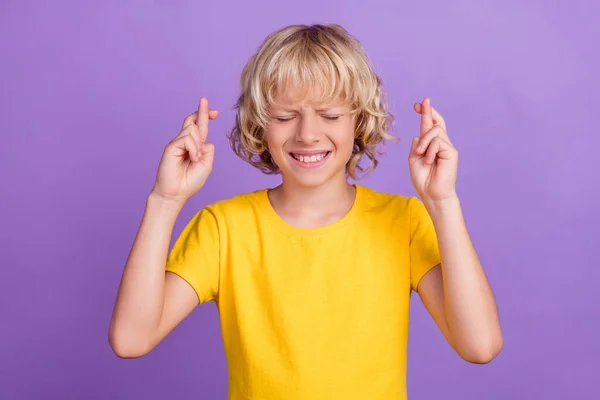 Foto de niño nervioso preocupación duro examen cruzado dedos desgaste amarillo camiseta aislado color violeta fondo —  Fotos de Stock