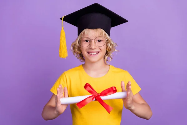 Fénykép csinos iskolás fiú viselni sárga póló szemüveg végzős elemi szintű mosolygós elszigetelt lila színű háttér — Stock Fotó