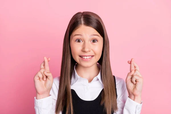 Foto de niña de la escuela feliz sonrisa positiva cruzada manos deseo suerte examen cruzado dedos aislados sobre fondo de color rosa —  Fotos de Stock