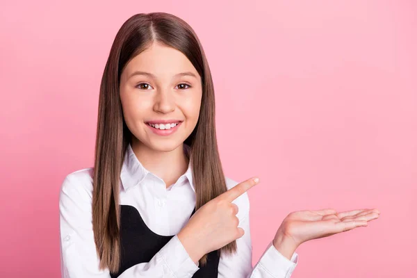 Zdjęcie młodej uczennicy szczęśliwy uśmiech pozytywny wskazuje palcem produkt promocyjny oferta izolowane na różowy kolor tła — Zdjęcie stockowe