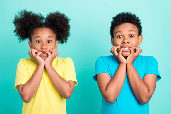 Foto de morena asustada niña niño morder dedos usar camiseta aislada sobre fondo de color verde azulado — Foto de Stock