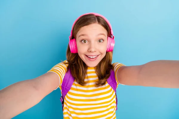 Foto de menina bonito alegre fazer selfie radiante sorriso de volta para aprender a ter bom humor isolado no fundo de cor azul — Fotografia de Stock