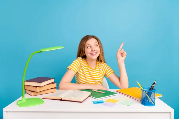 Portret van positief klein meisje kijken directe vinger lege ruimte propositie tips geïsoleerd op blauwe kleur achtergrond — Stockfoto